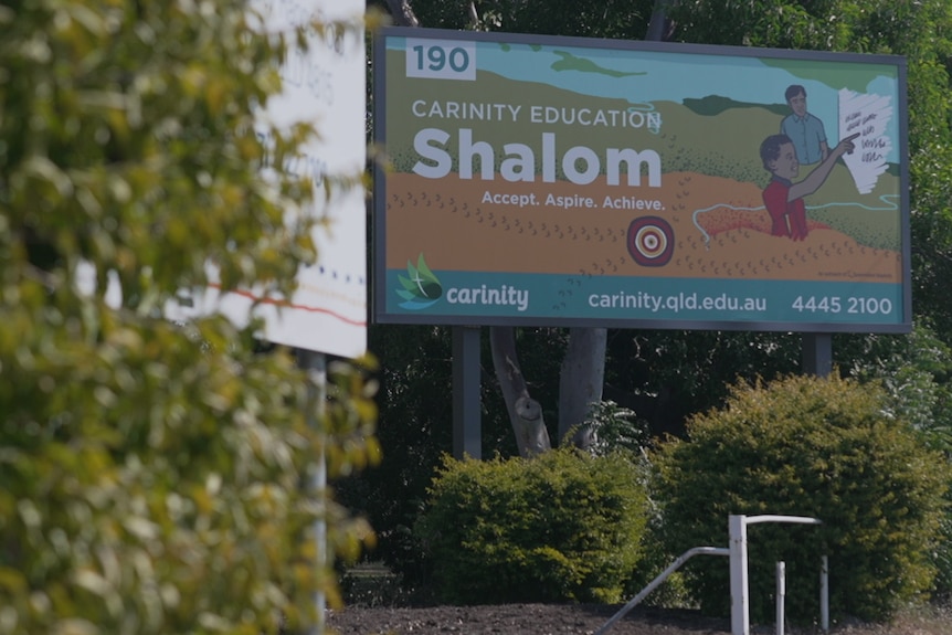 a billboard that says shalom in large white letters and artwork of children with a tree in foreground