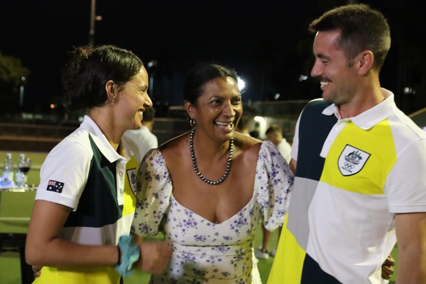 Brooke Peris, Nova Peris and Jeremy Hayward share a laugh together on a hockey field.