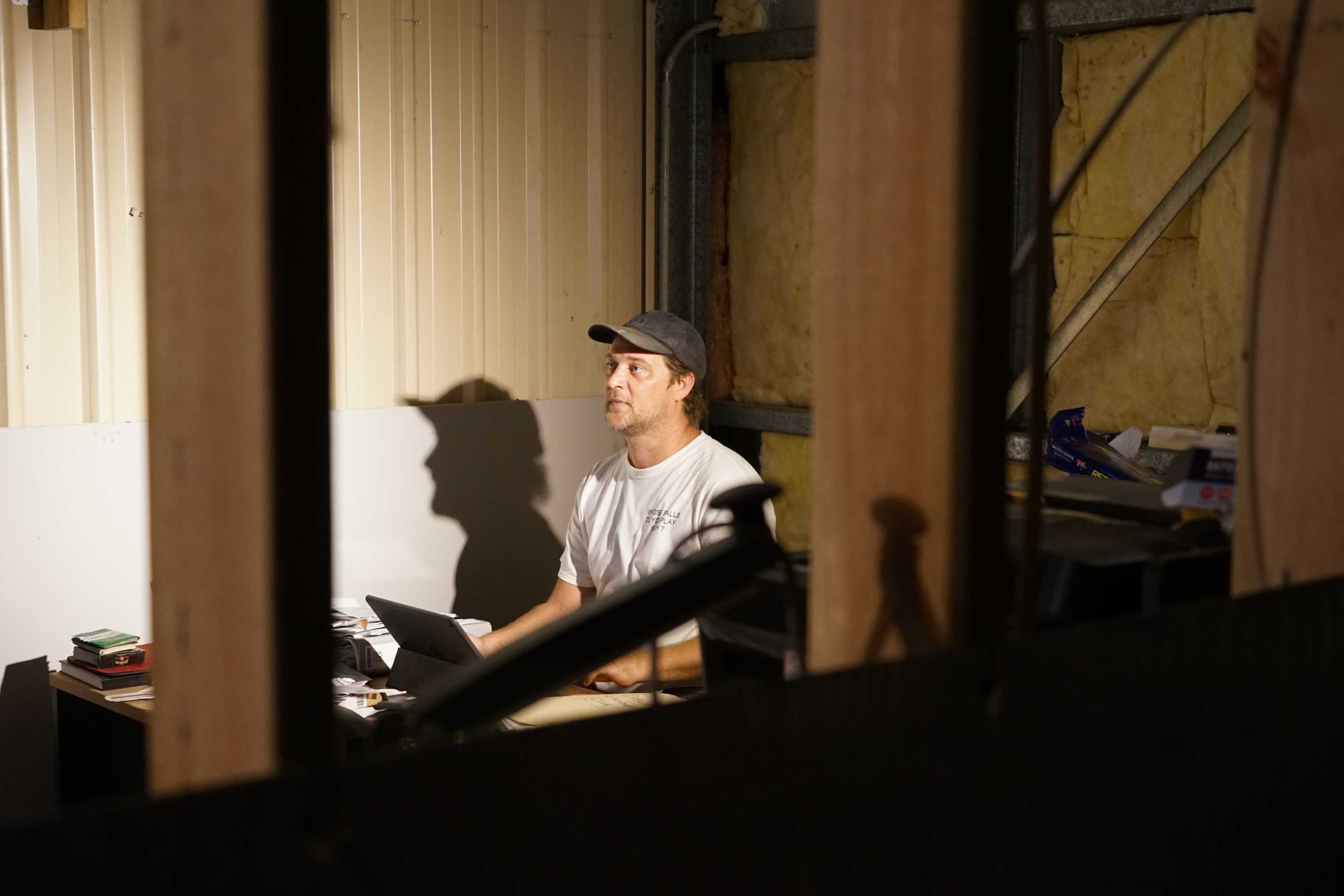 Paul Manwaring at work on his computer at his Humpty Doo workshop