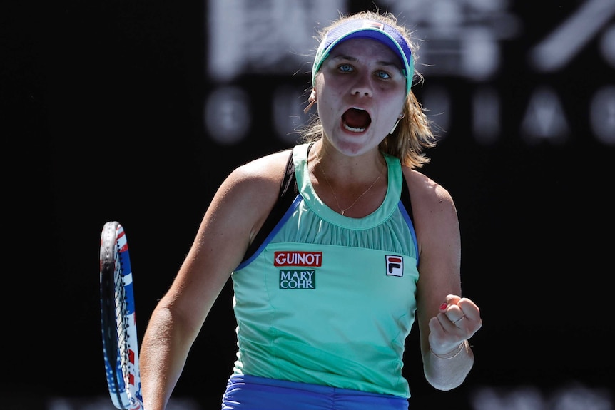 A female tennis screams out and pumps her fist as she celebrates winning a point at the Australian Open.