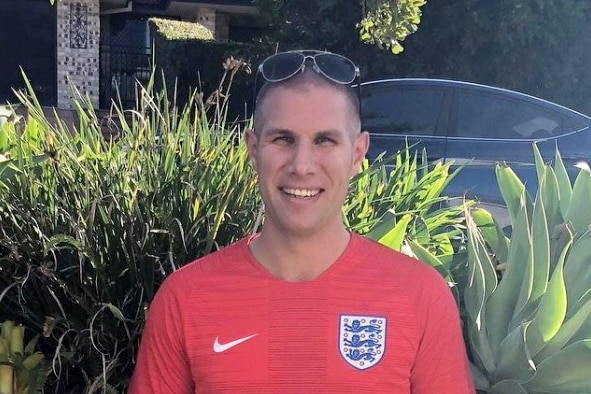 Andy Jones smiles in a soccer jersey. 