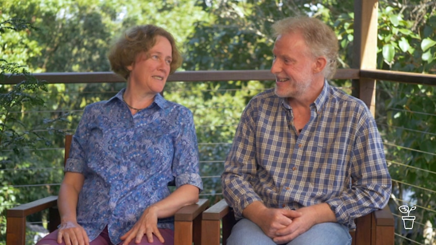 Man and woman sitting on deck smiling at each other