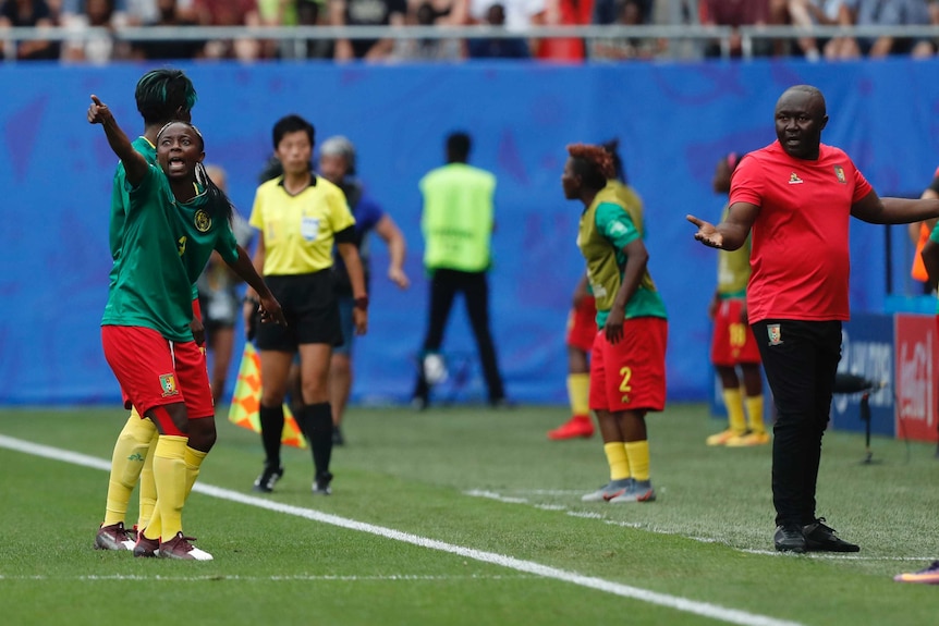 A soccer player and her coach react with disbelief after a decision goes against them.