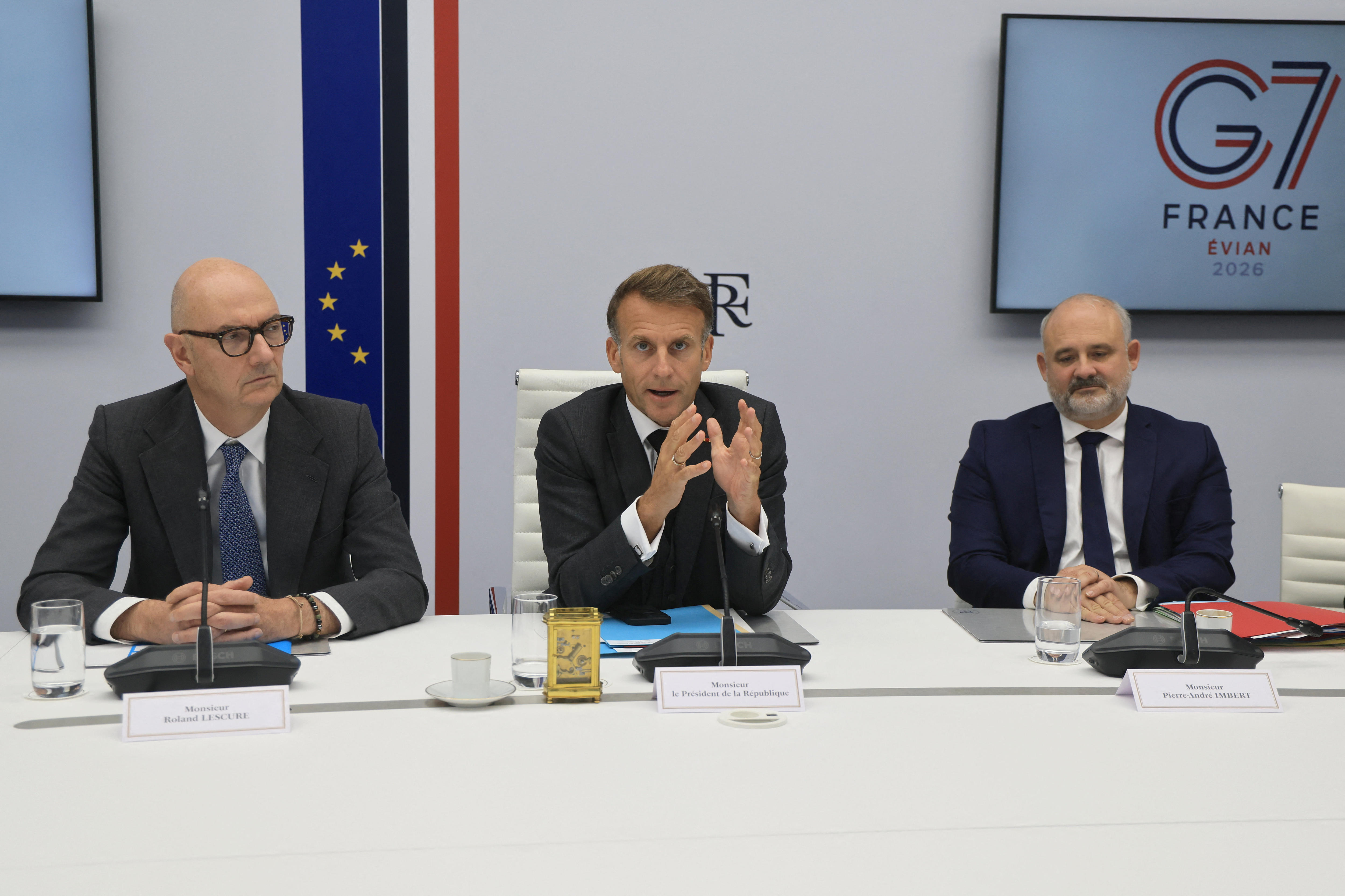 Three politicians sit at a desk.