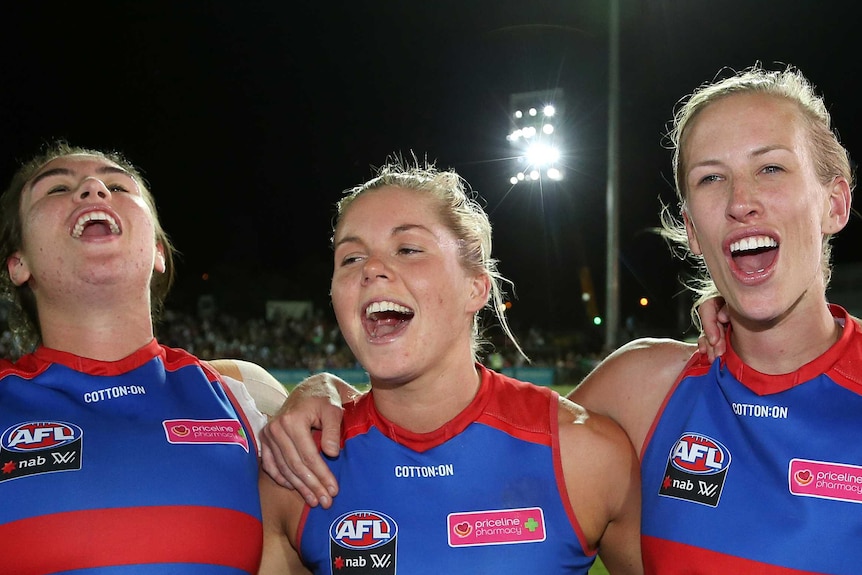 Bonnie Toogood, Katie Brennan and Bailey Hunt celebrate the Western Bulldogs' AFLW win over Melbourne