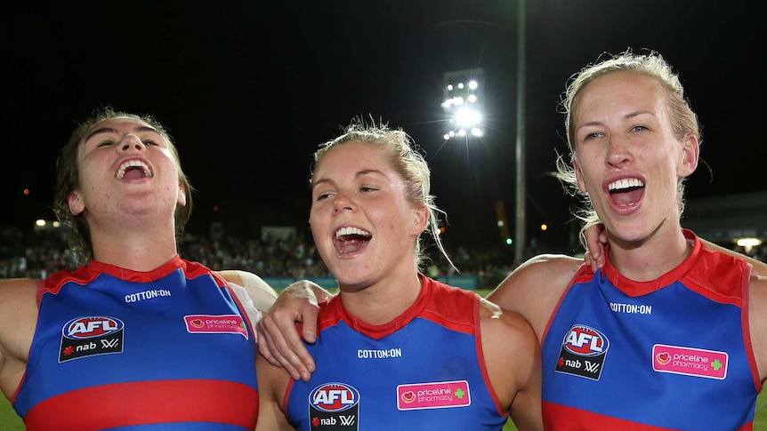 Bonnie Toogood, Katie Brennan and Bailey Hunt celebrate the Western Bulldogs' AFLW win over Melbourne