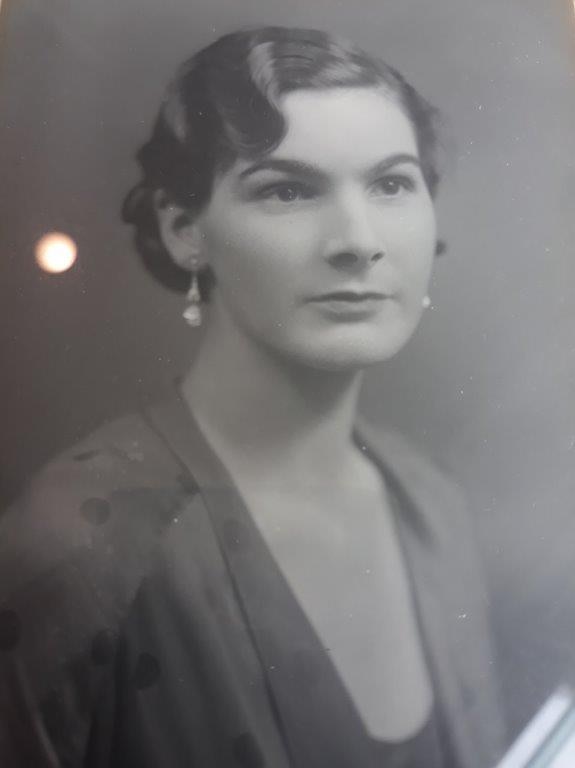 Old black and white portrait of a woman with short dark hair, aged about 21