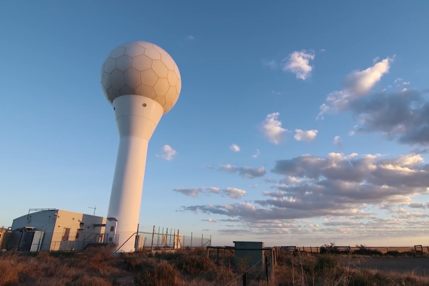 A weather radar that looks like a giant golf ball on a tee set against a blue sky
