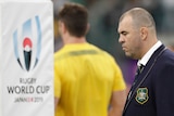 An Australian rugby union coach stands next to a goalpost before a Rugby World Cup quarterfinal.
