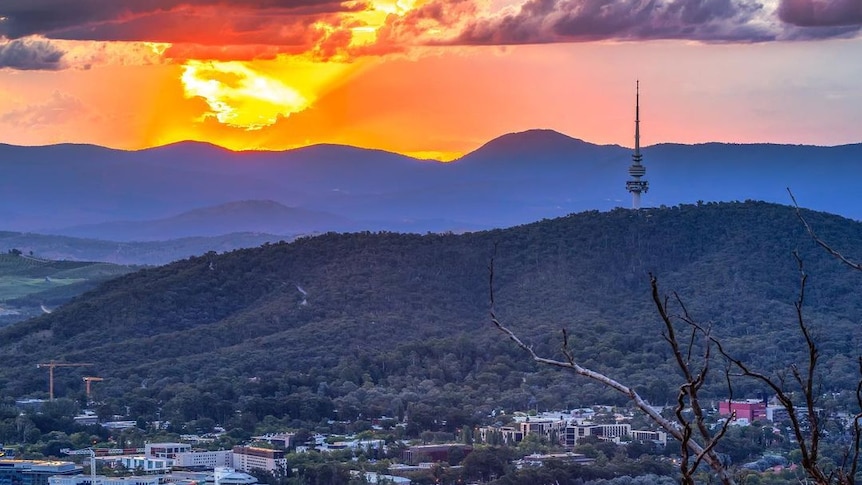 The sun is setting behind hills of Canberra