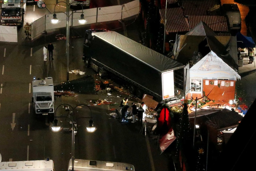 Rescuers and police investigators stand around a victim in Berlin