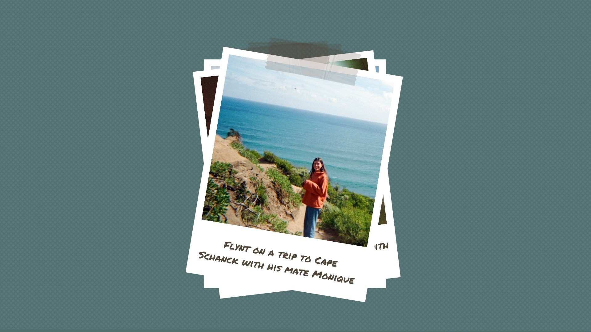 A young woman stands on a cliff with a hand raised to her face blocking the sun