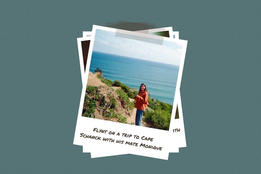 A young woman stands on a cliff with a hand raised to her face blocking the sun