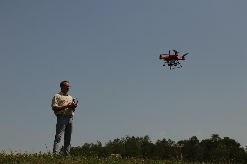A man flying a drone. 