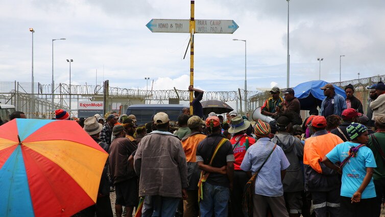 A group of men stand in front of man holding a megaphone protesting in Papua New Guinea's Hela Province.