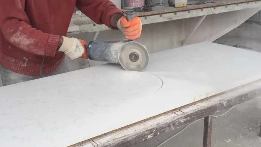A man cutting stone for a kitchen benchtop