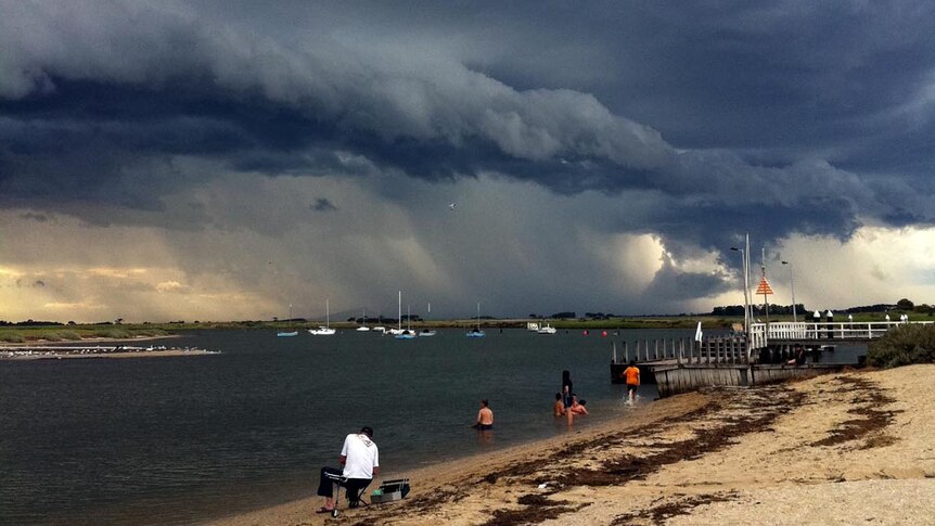 Life goes on as normal at Werribee South as a storm front looms over Melbourne.