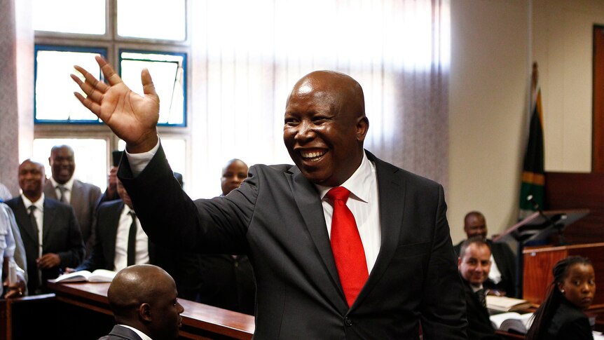 Julius Malema waves to supporters during his court appearance