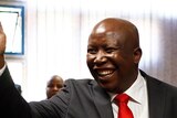 Julius Malema waves to supporters during his court appearance