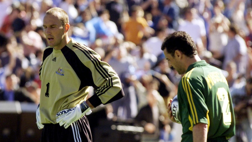 Two soccer players look dejected after a loss.