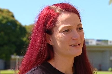 Close up of woman with long red hair talking. 