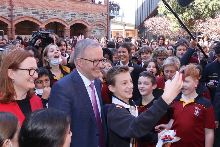 Albanese poses for a selfie with a crowd of students.