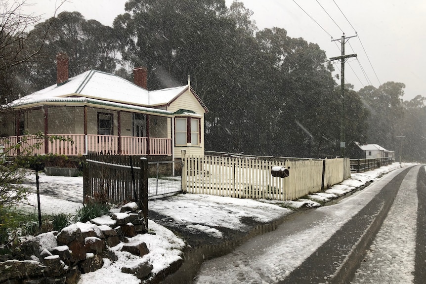 Snow falls on a house