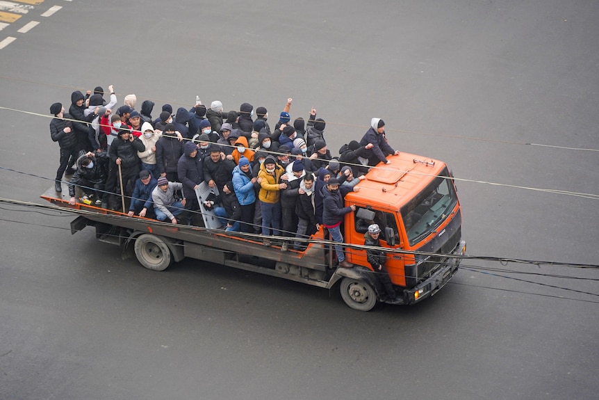 Demonstrators ride a truck during a protest.