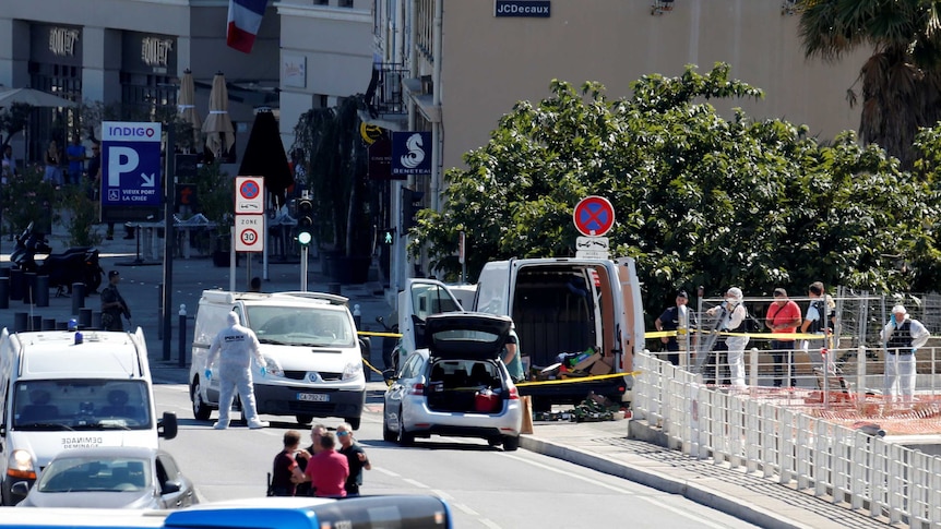 French police conduct their investigation in Marseilles. Officers in forensic coveralls are inspecting the scene.