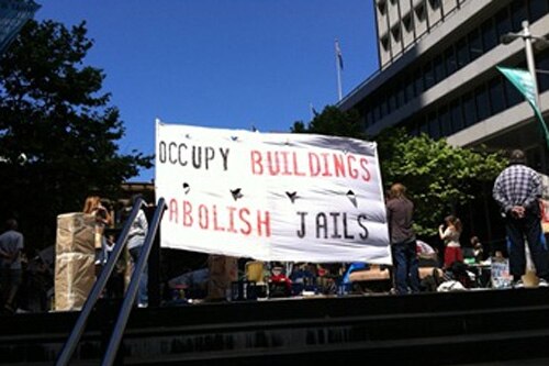 Sign reads: Occupy Buildings Abolish Jails