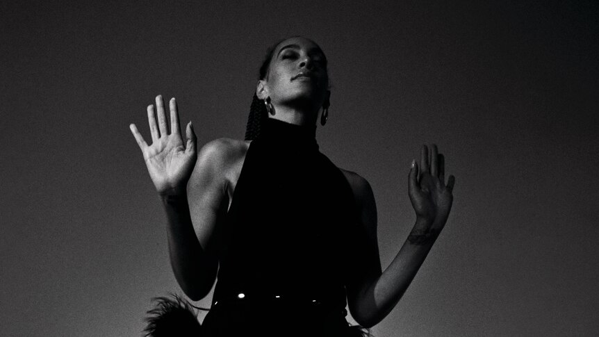 black and white photo of Solange, shot from below. She has her hands out in front of her