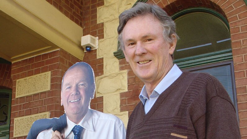 Mr Taylor stands alongside a cutout of John Bowler in Kalgoorlie this morning.