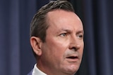A head and shoulders shot of Mark McGowan speaking during a media conference indoors.