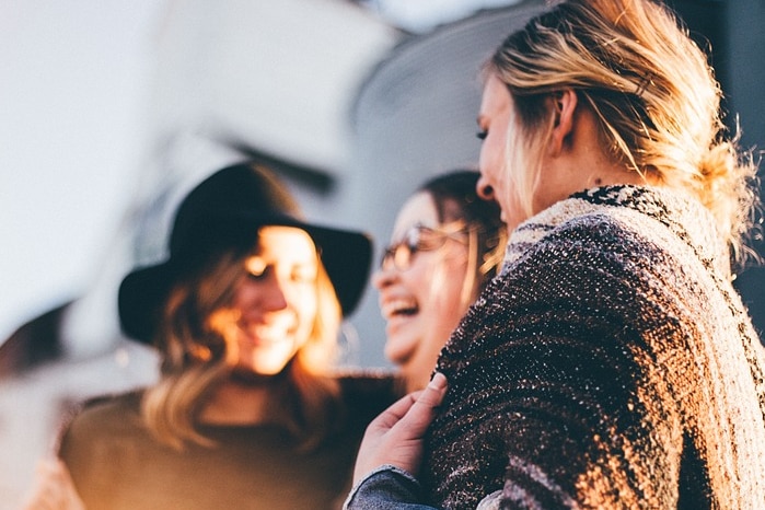 Three women talking and laughing.