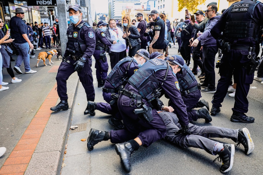 police hold a protester down on the ground
