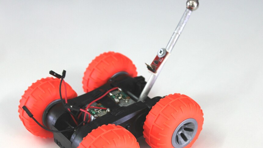 A four-wheeled robot with a metal tail.