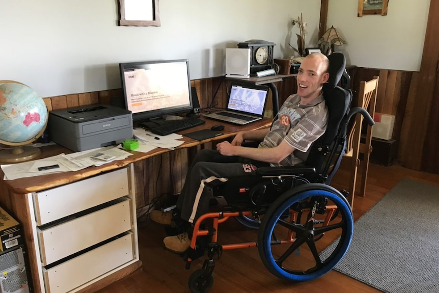 A man sits by his computer creating a website for people with disabilities