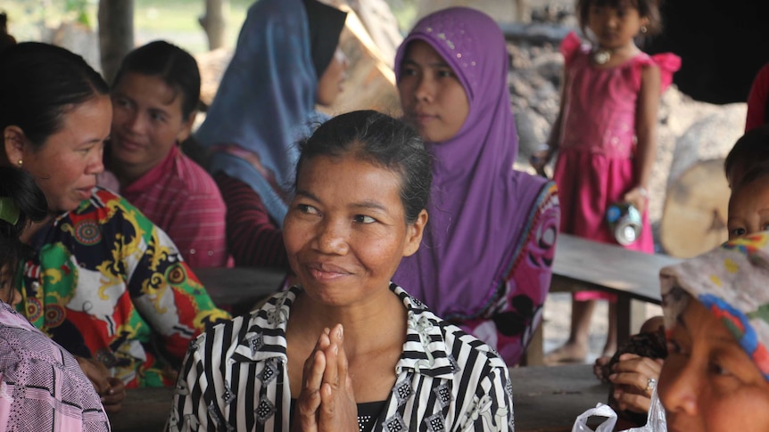 Cambodian women at a We Can Do It! research focus group discussion with her hands together smiling.