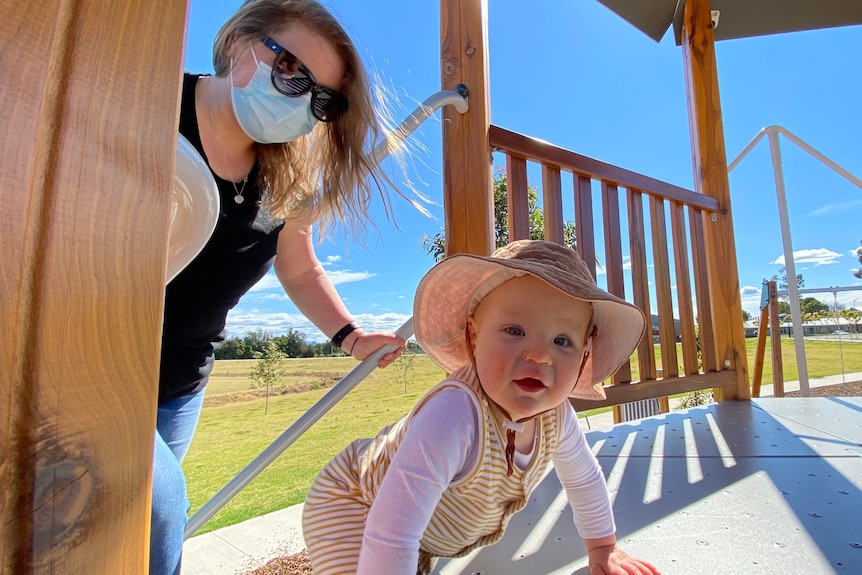 Jenny Quinn and her one-year-old son climb onto playground equipment