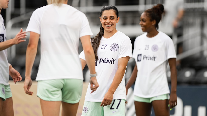 Alex Chidiac laughs with Racing Louisville FC teammates.