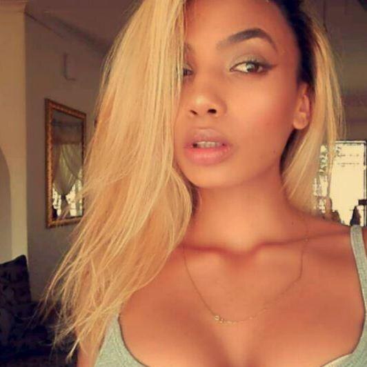 Zimbabwean model Gabriella Engels, 20, looks just off camera in a selfie. She is wearing a grey singlet and gold chain necklace