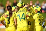 Australian players in a huddle as they celebrate a West Indian wicket in their Women's Cricket World Cup semi-final.
