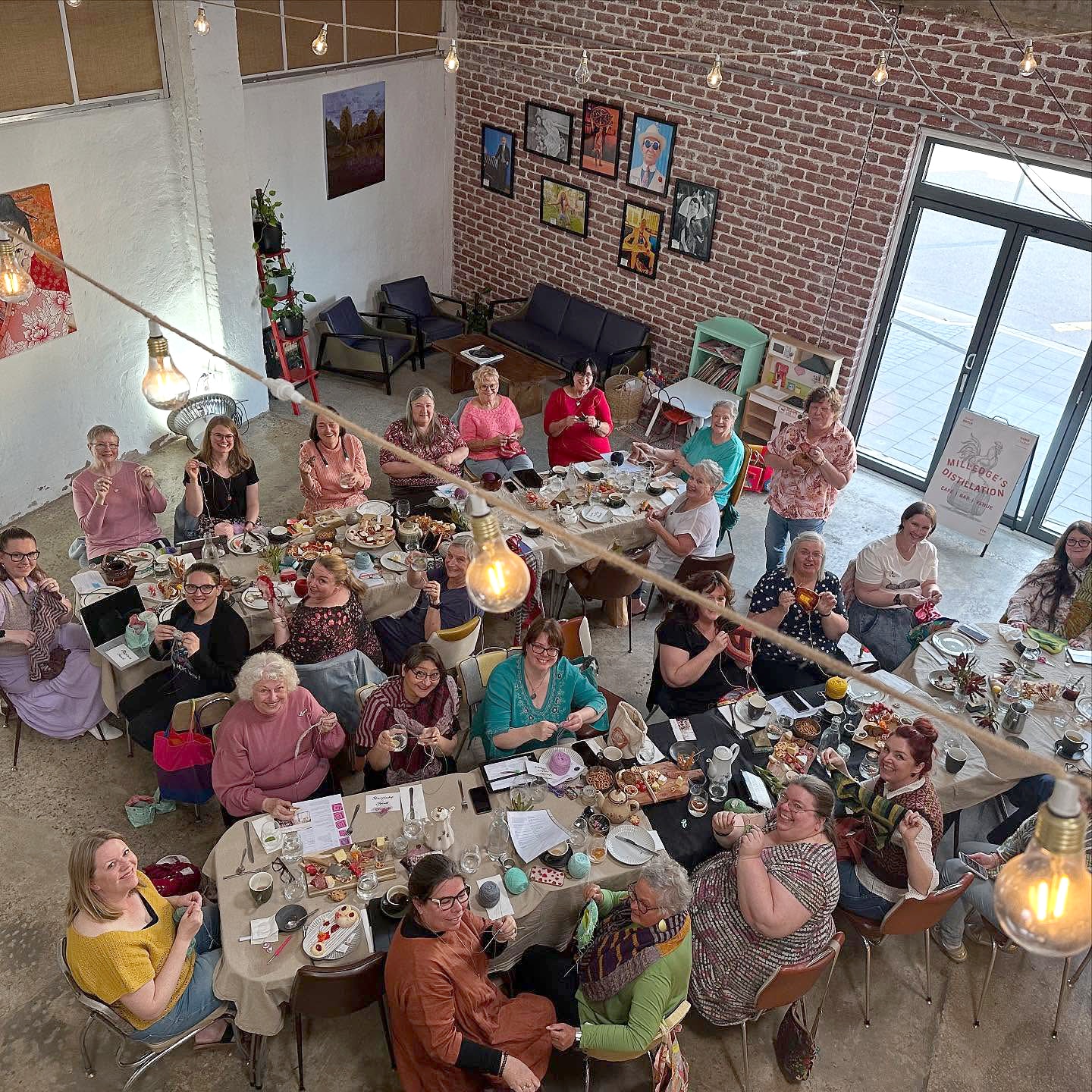 A group of ladies are around tables in a large room
