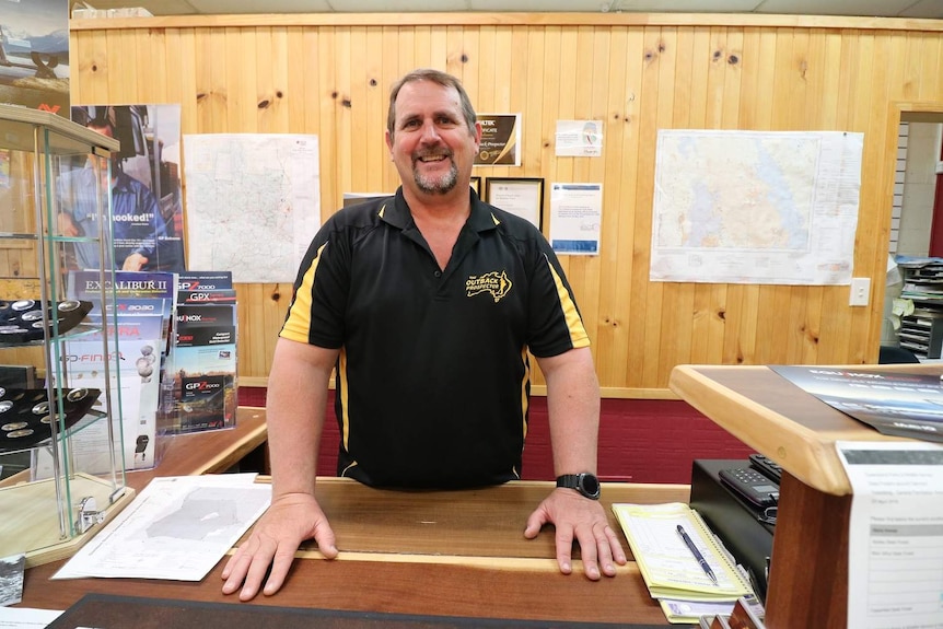 Jonathan Porter stands behind a desk in the Outback Prospector store in Clermont