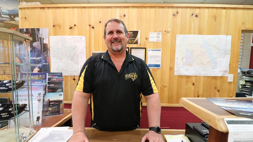 Jonathan Porter stands behind a desk in the Outback Prospector store in Clermont
