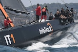 A yacht sails on Sydney Harbour in the early stages of the Sydney to Hobart yacht race.