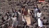 Television image of Yemeni tribesmen standing next to a plane bearing a Moroccan flag