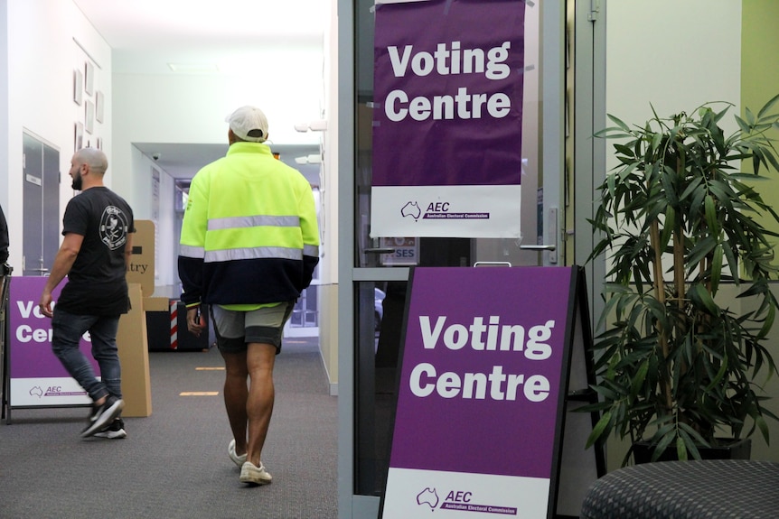 Inside a voting booth with purple signage 