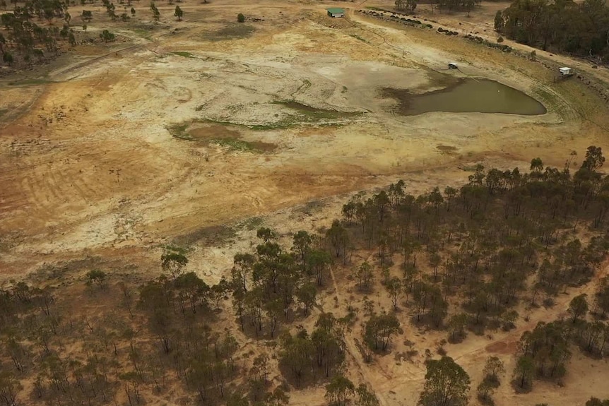 An aerial shot of a very low dam with brown, dry land around.