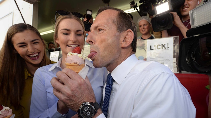 Flanked by his daughters, Tony Abbott eats a sundae at the Brisbane Ekka.